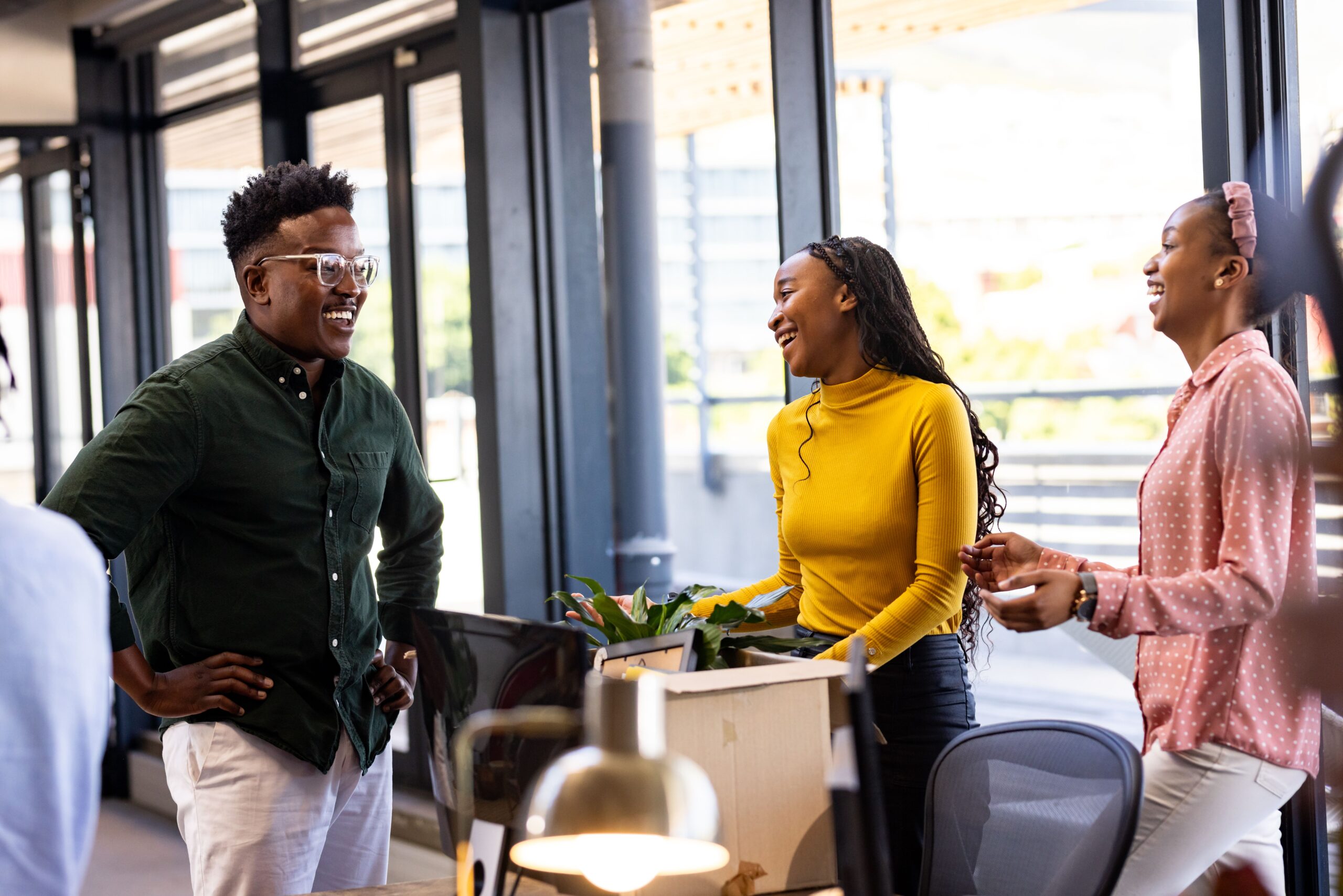 Colleagues in modern office laughing and discussing creative project together. Teamwork, collaboration, brainstorming, business, innovation, corporate